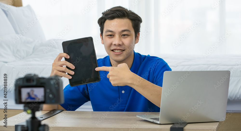 Asian technology blogger showing tablet to audience Asian technology blogger showing tablet to audience