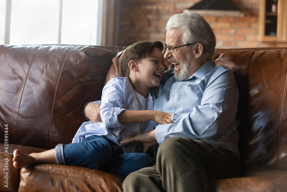 Overjoyed senior 60s grandfather have fun play in living room with excited little 7s grandson. Loving mature Caucasian granddad feel playful engaged in funny game relax with small grandchild at home. Overjoyed senior 60s grandfather have fun play in living room with excited little 7s grandson. Loving mature Caucasian granddad feel playful engaged in funny game relax with small grandchild at home.