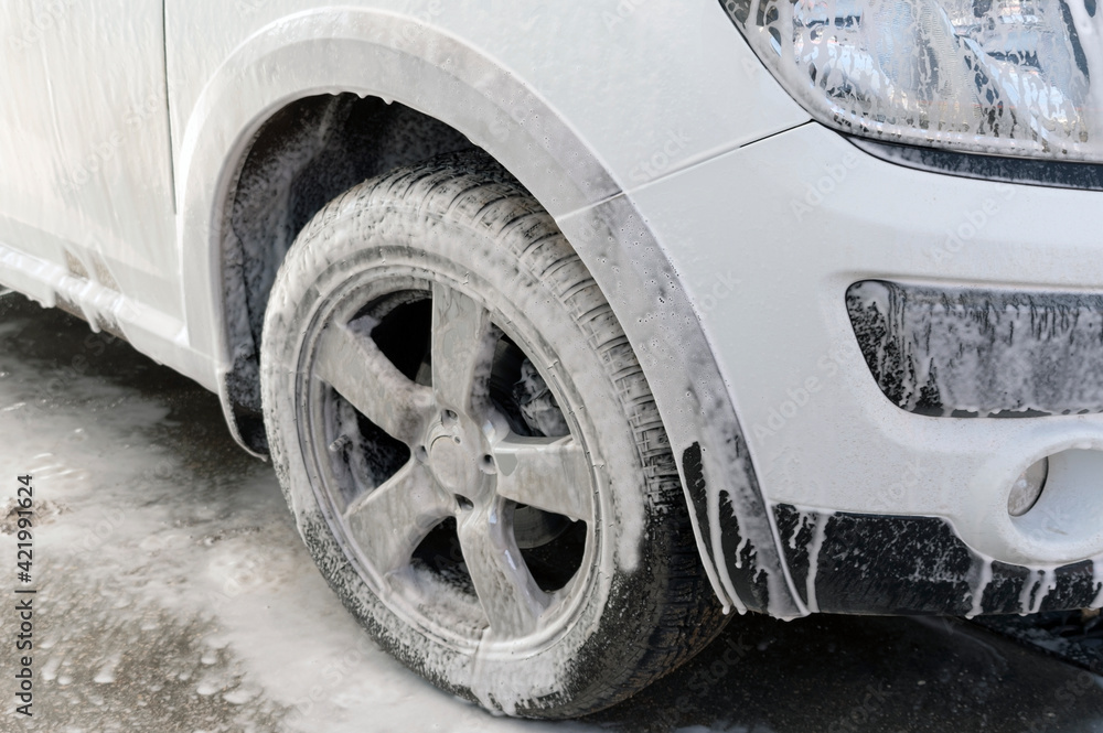 car in soap foam on the car wash