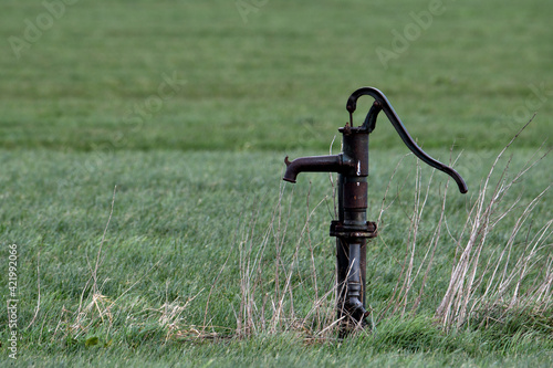 Old fashioned hand water pump in a field close to Oss, Netherlands