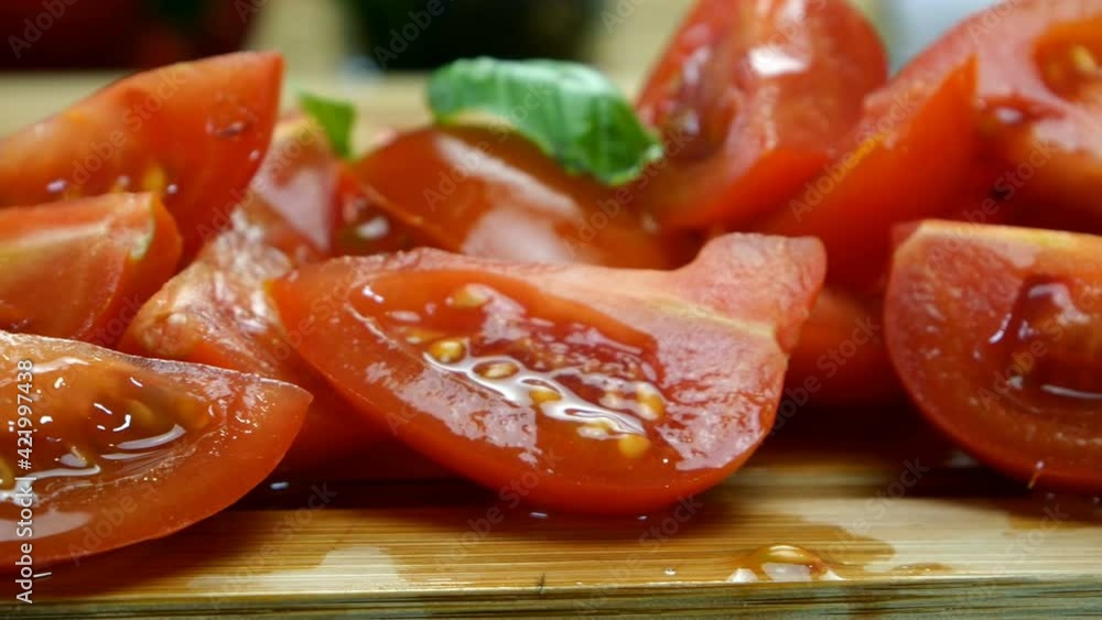 Sliced cherry tomato into pieces on wooden cutting board for preparing delicious food. Home kitchen. Left to right dolly. Close-up. Sliced cherry tomato into pieces on wooden cutting board for preparing delicious food. Home kitchen. Left to right dolly. Close-up.