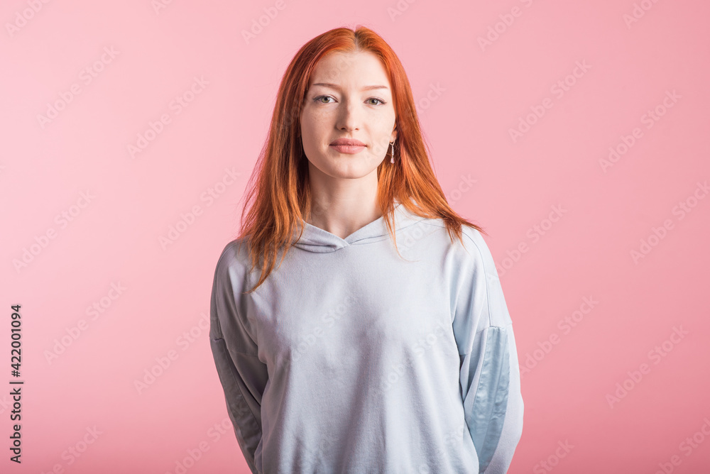 Portrait of a satisfied redhead girl in the studio on a pink background Portrait of a satisfied redhead girl in the studio on a pink background