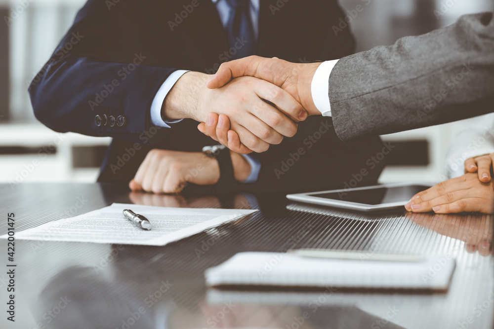 Obraz premium Handshake as successful negotiation ending, close-up. Unknown business people shaking hands after contract signing in modern office