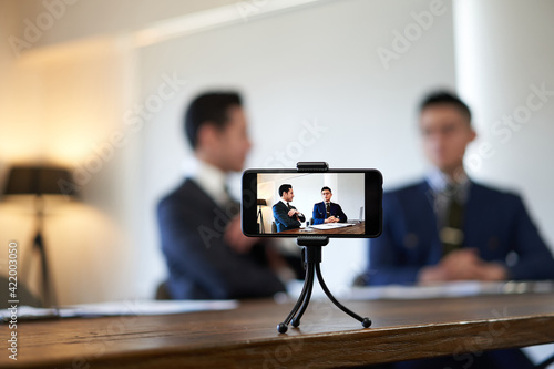 ビジネスの対談動画を撮影するビジネスマン © mapo