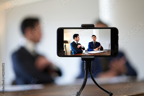 Foto ビジネスの対談動画を撮影するビジネスマン