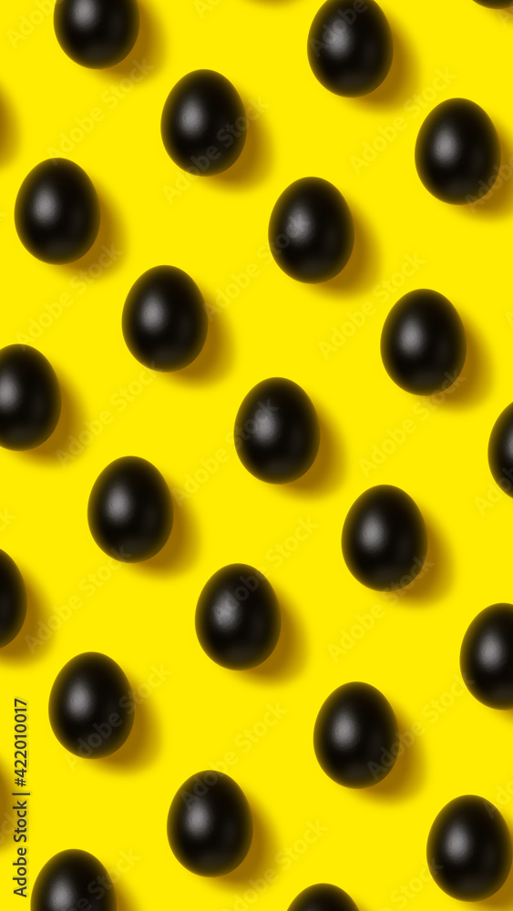 Easter pattern made with black painted eggs on vibrant yellow background. Minimal food concept. Flat lay. Easter pattern made with black painted eggs on vibrant yellow background. Minimal food concept. Flat lay.