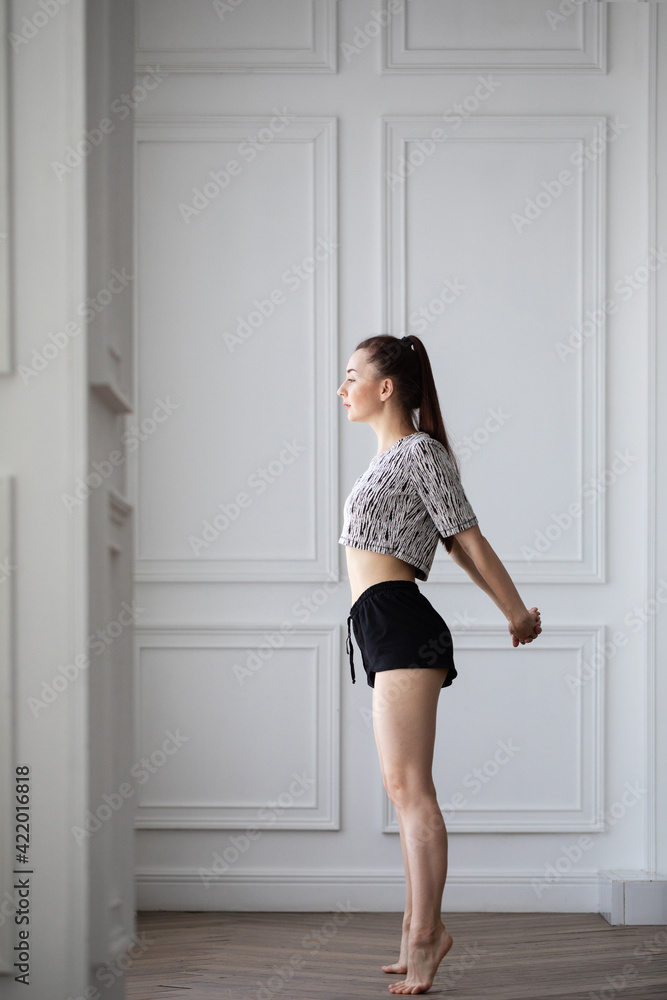 Beautiful girl doing exercises in the morning near the window, posing. Beautiful girl doing exercises in the morning near the window, posing.
