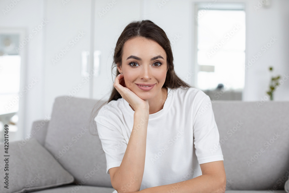 Smiling happy woman sitting on the couch at home while online communication look at camera, Smiling happy woman sitting on the couch at home while online communication look at camera,