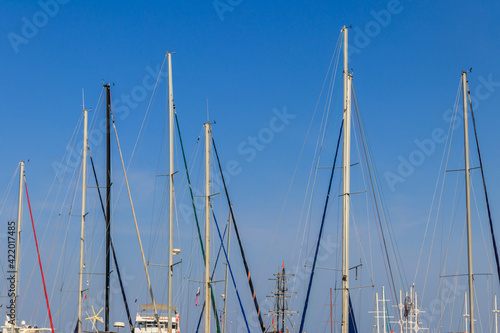 Masts of sailboats against clear blue sky