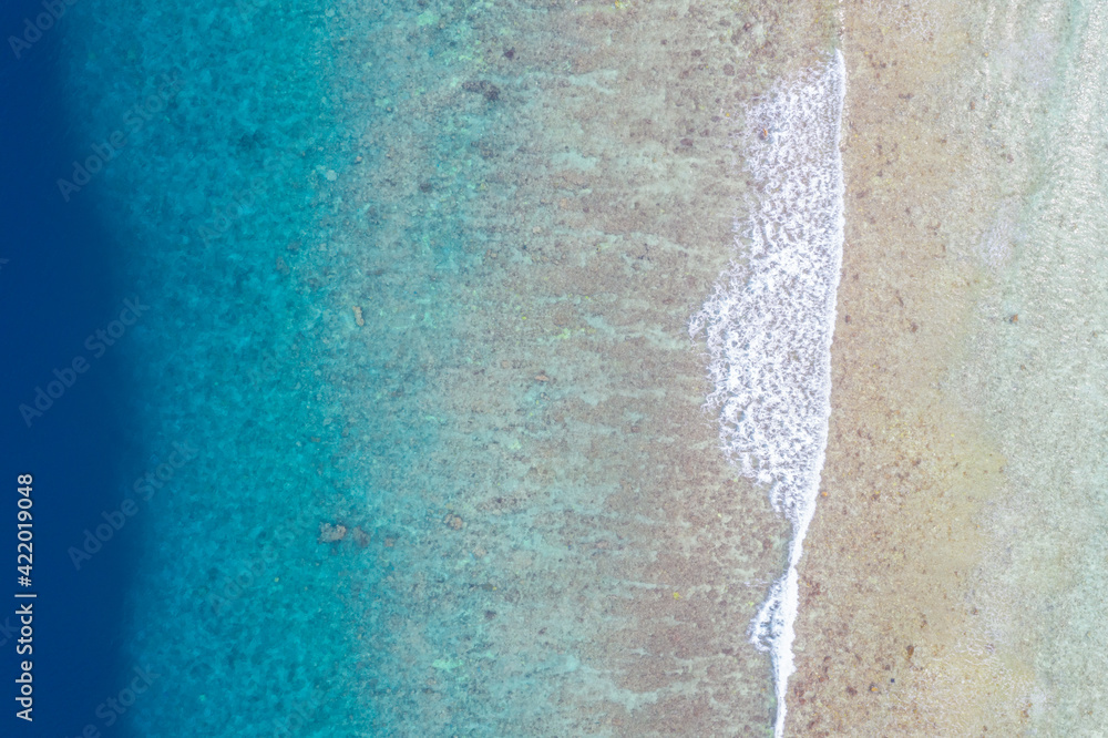 Wave on coral beach beautiful natural shore, coast background at the summer time. Tropical nature pattern, sea ocean surface, top aerial view. Blue shades with surf waves Wave on coral beach beautiful natural shore, coast background at the summer time. Tropical nature pattern, sea ocean surface, top aerial view. Blue shades with surf waves