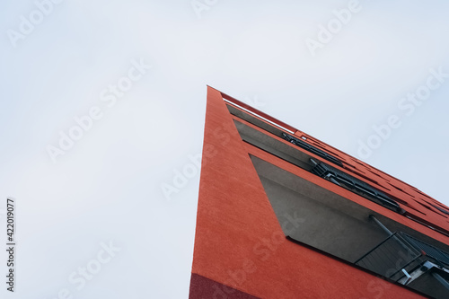 A fragment of a modern building with a geometric shape against a blue sky.Urban abstract futuristic architecture in the style of minimalism creates a geometric stylish pattern.Vertical orientation