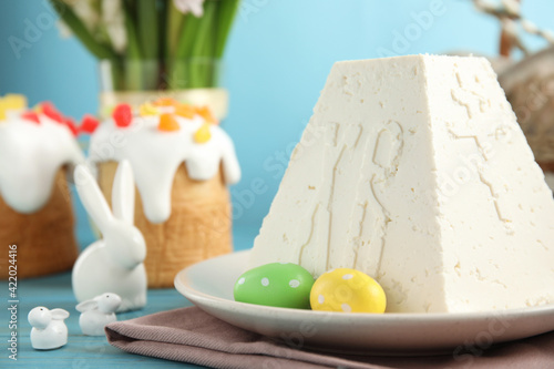 Traditional cottage cheese Easter paskha on light blue wooden table, closeup. Space for text