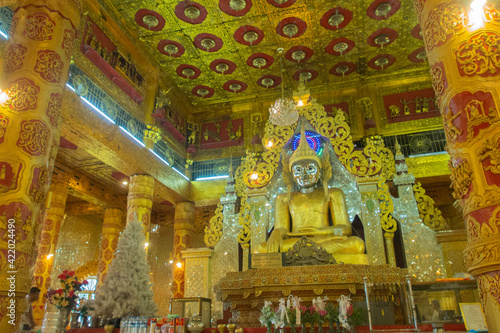a golden Buddha statue in popular temple at Kyaw Tha, Myanmar © Sigitpramono