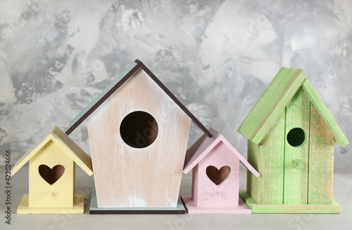 Collection of handmade bird houses on light grey stone background