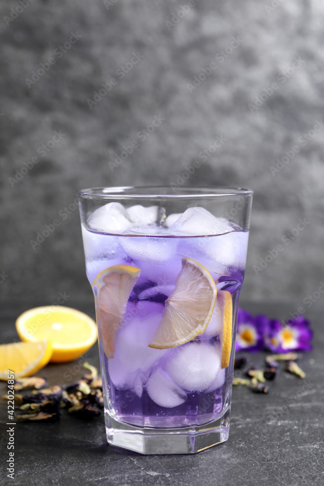 Organic blue Anchan with lemon in glass on grey table. Herbal tea Organic blue Anchan with lemon in glass on grey table. Herbal tea