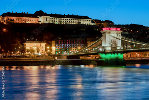 The famous Chain bridge in Budapest festive illuminated with national flag colours due national celebrate day. Zhis day is march 15. the memorial day od 1848-48 revolutional liberty war photo