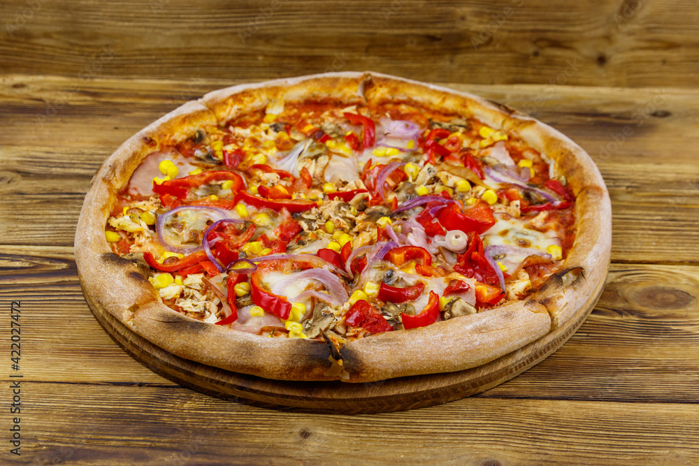 Delicious fresh pizza on a wooden table Delicious fresh pizza on a wooden table