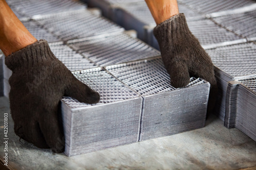 Worker sorting new plumb battery plates. Closeup photo. Accumulators recycling.