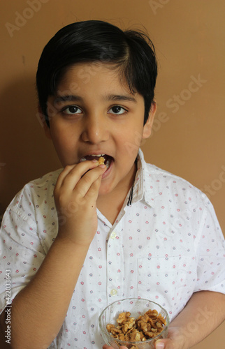 Cute Indian child eating walnuts