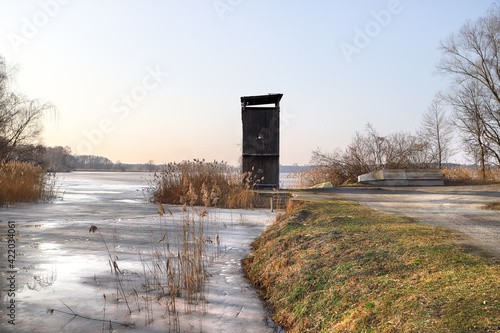 WROCLAW, POLAND - FEBRUARY 22, 2021: Frozen lake landscape. The Milicz Ponds (Polish: Stawy Milickie). Nature Reserve in Barycz Valley Landscape Park. Lower Silesian Voivodeship, Poland, Europe.