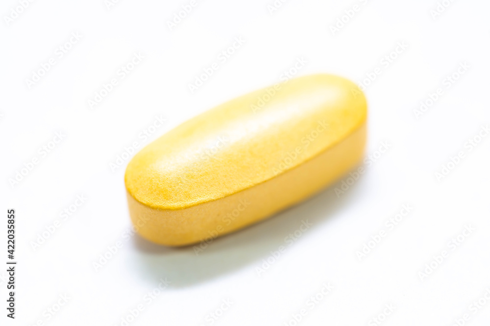 Orange medicinal pill close up macro shot isolated on white background. Orange medicinal pill close up macro shot isolated on white background.