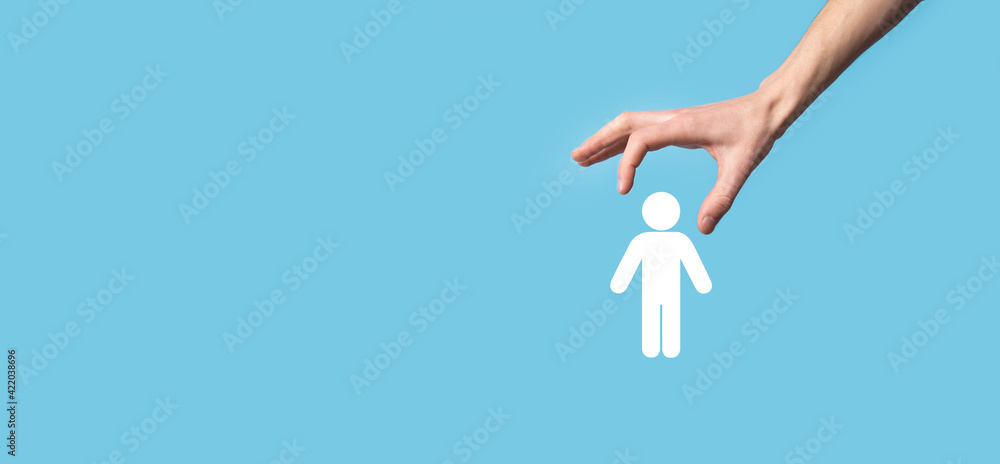 Fototapeta premium Male hand holding human icon on blue background. Human Resources HR management Recruitment Employment Headhunting Concept.Select team leader concept. Male hand click on man icon.Banner ,copy spase.