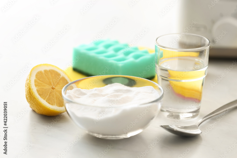 Baking soda, lemon and vinegar on light stone table. Eco friendly detergents Baking soda, lemon and vinegar on light stone table. Eco friendly detergents