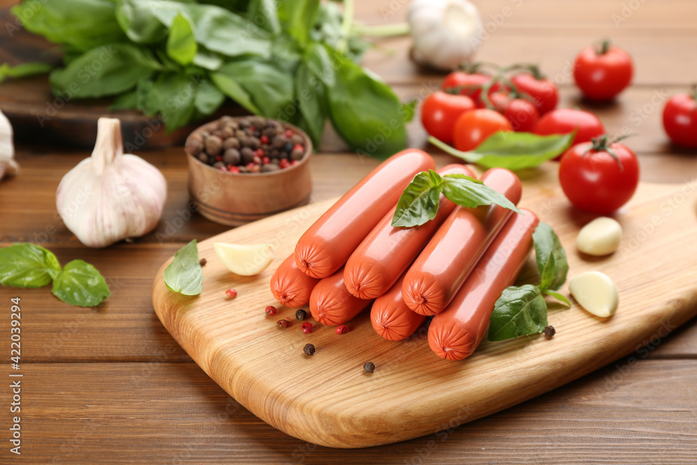 Fresh raw vegetarian sausage with basil and vegetables on wooden table Fresh raw vegetarian sausage with basil and vegetables on wooden table