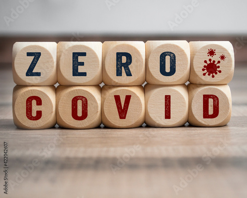 Cubes, dice or blocks with zero covid on wooden background photo