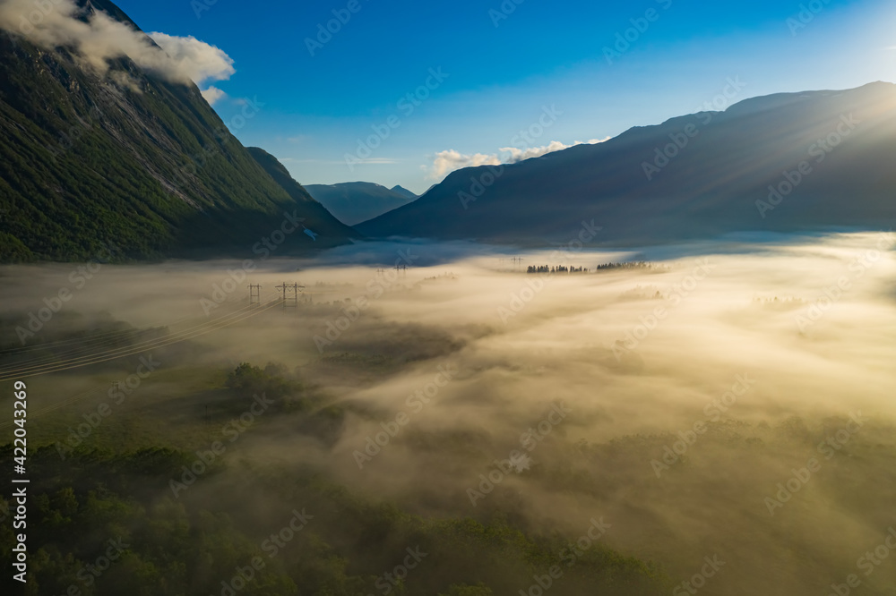 Morning mist over the valley among the mountains in the sunlight. Fog and Beautiful nature of Norway aerial footage. Morning mist over the valley among the mountains in the sunlight. Fog and Beautiful nature of Norway aerial footage.
