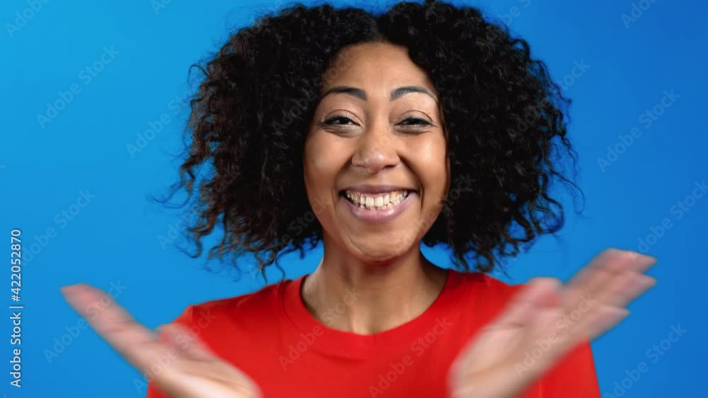 African woman is very glad and happy, she claps hands because of excellent news. Surprised excited happy lady applauding on blue background African woman is very glad and happy, she claps hands because of excellent news. Surprised excited happy lady applauding on blue background