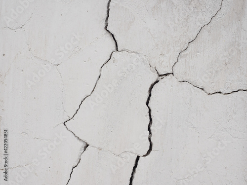 Cracks on the white wall.