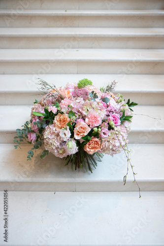 Fototapeta Naklejka Na Ścianę i Meble -  a large bouquet of pink, white flowers, on a light staircase. Bouquet, composition for a holiday, celebration. Flower trade, private business, floristic decoration