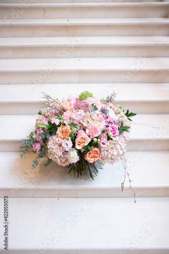 a large bouquet of pink, white flowers, on a light staircase. Bouquet, composition for a holiday, celebration. Flower trade, private business, floristic decoration