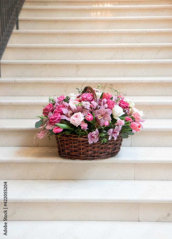 a large basket of flowers, a bouquet of pink, white flowers, on a light background. Bouquet, flower arrangement for a holiday, celebration. Flower trade, private business, floristic decoration
