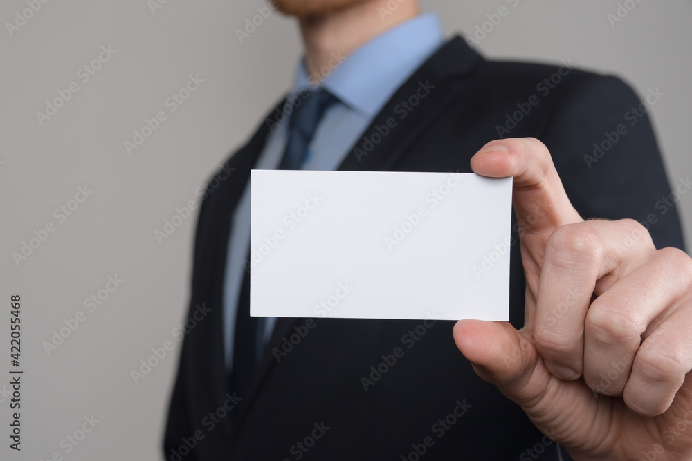 Businessman ,Business Man's hand hold showing business card - close up shot on grey background. Show a blank piece of paper. Paper visit card Businessman ,Business Man's hand hold showing business card - close up shot on grey background. Show a blank piece of paper. Paper visit card