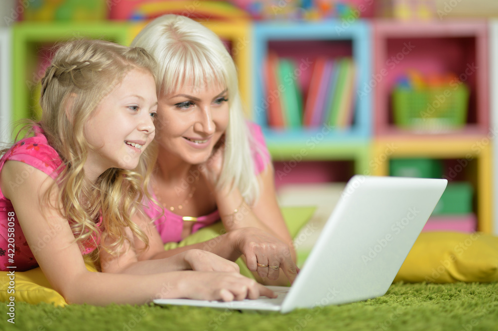 portrait of smiling mother and daughter using laptop portrait of smiling mother and daughter using laptop