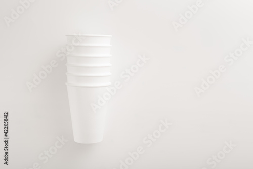 white disposable styrofoam cups on white background with copy space for text. food delivery home delivery business concept. Flat lay. disposable tableware for outdoor recreation.