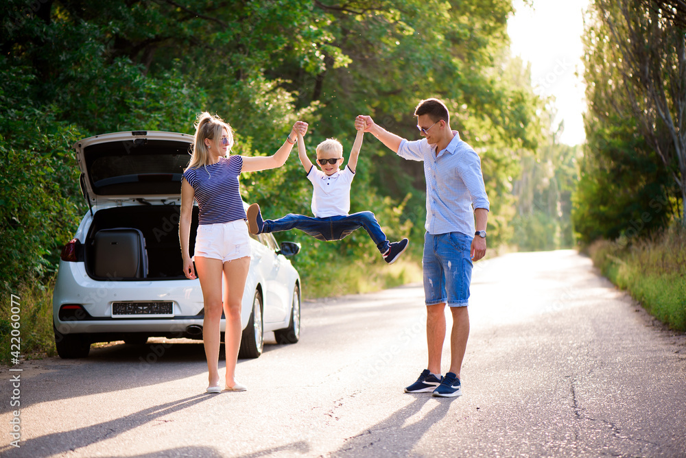Young family travels by car. Dad, mom and son take a break from driving a car and walk. Young family travels by car. Dad, mom and son take a break from driving a car and walk.