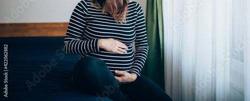 Pregnant woman enjoying baby's movement in her belly. Closeup image. 