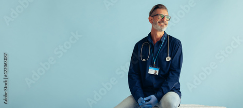 Mature doctor on blue background