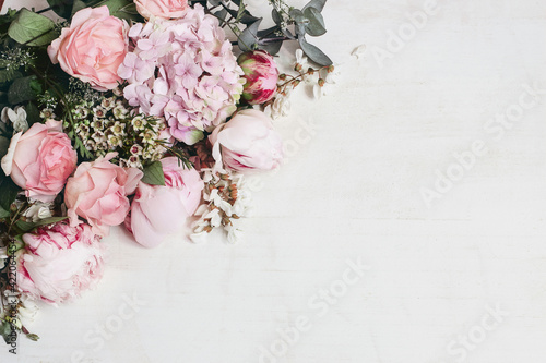 Fototapeta Naklejka Na Ścianę i Meble -  Spring, summer floral still life. Closeup of pink roses, hydrangeand peonies flowers. Bouquet of Eucalyptus isolated on white wooden background. Decorative corner, web banner. Flat lay, top view.
