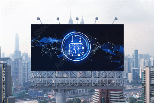 Padlock icon hologram on road billboard over panorama city view of Kuala Lumpur at day time to protect business, Malaysia, Asia. The concept of information security shields.