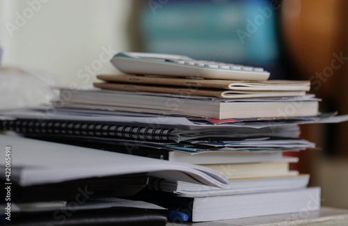 Stacked books and documents on the table