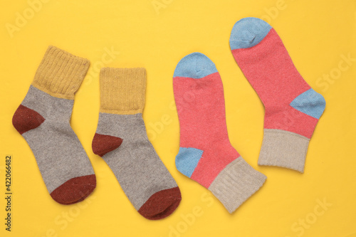 Warm colored socks on a yellow background. Top view