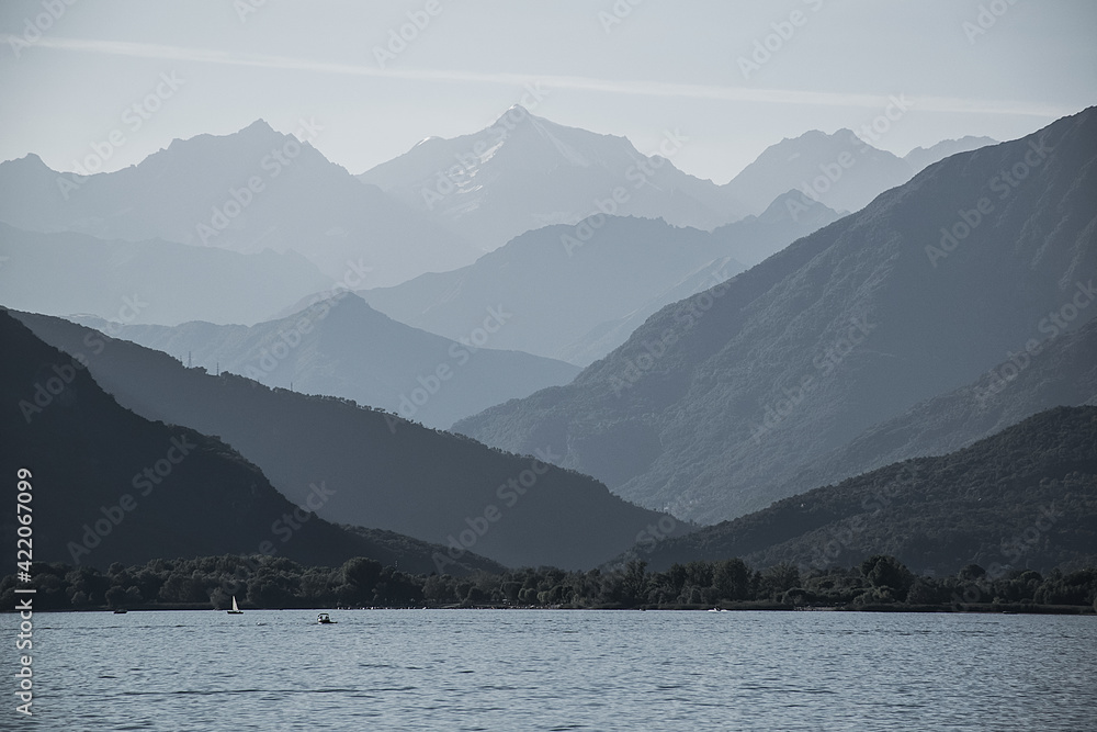 Majestic peaks rise above the vast expanses of Lake Maggiore in Italy. The contour lighting creates a halftone perspective.