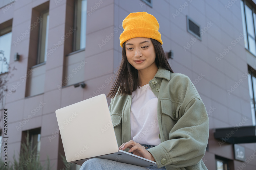 Portrait of young stylish designer at work. Asian woman using laptop computer, typing, working online. University student studying, learning, exam preparation, online education concept Portrait of young stylish designer at work. Asian woman using laptop computer, typing, working online. University student studying, learning, exam preparation, online education concept