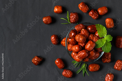 Foto Dried Jujube, Chinese dried red date fruit with Mint leaves in glass cup and ros
