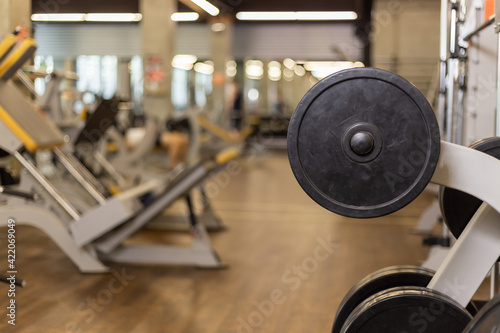 Barbell disc on blurred gym interior background