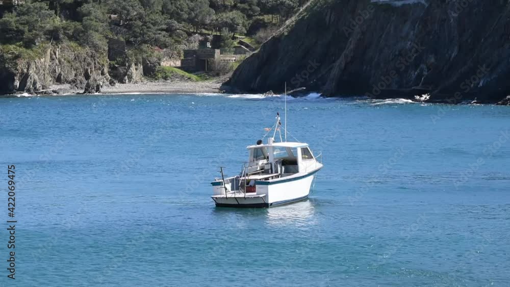 Seascape with a small boat near the rock coast Seascape with a small boat near the rock coast